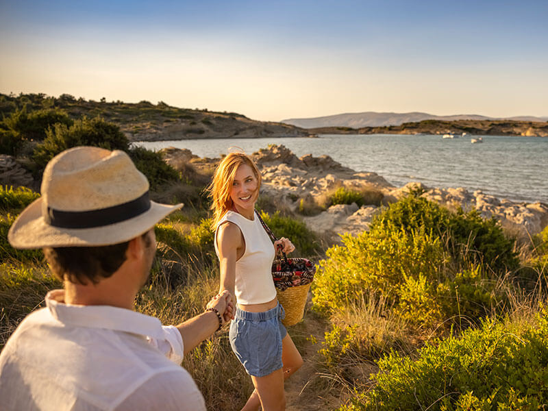 Couple marchant sur un sentier côtier au coucher du soleil sur l’île de Rab