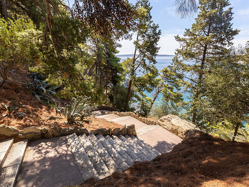 Forested trail overlooking the sea in Komrčar Park