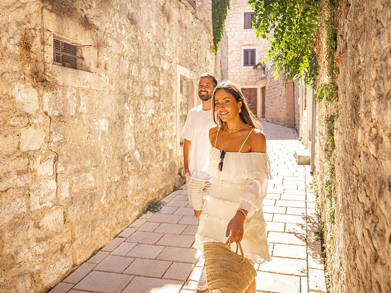 Couple walking through traditional stone streets on Rab Island