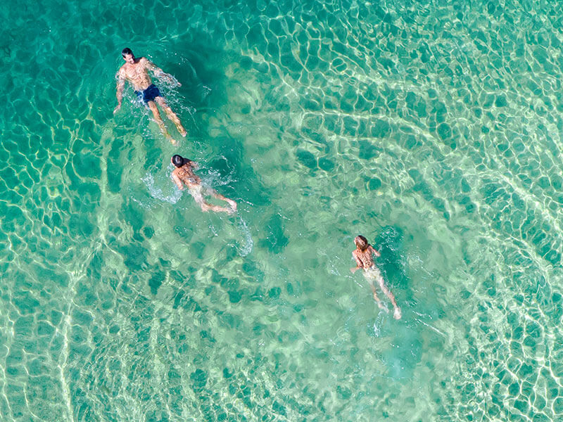 Gruppe schwimmt im kristallklaren türkisfarbenen Wasser