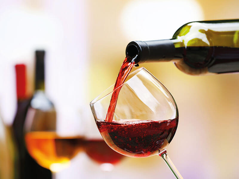 Točenje rdečega vina v elegantnem notranjem vinski baru