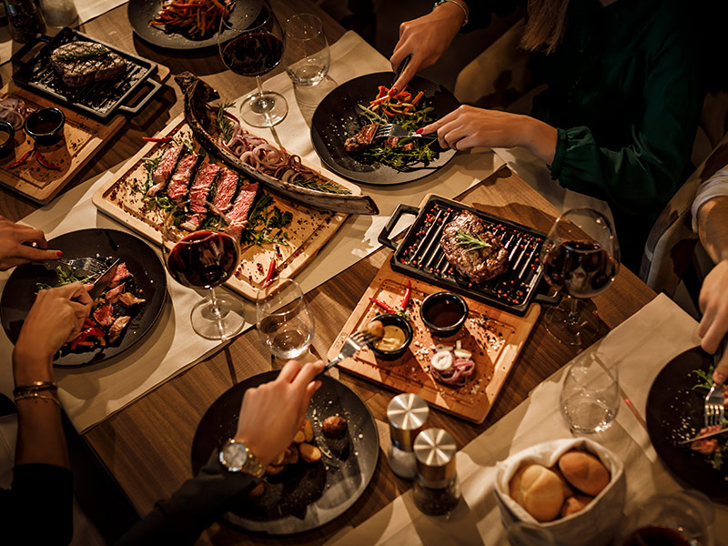 Stół pełen steków i dodatków w Black & Blue Steakhouse w Rabacu