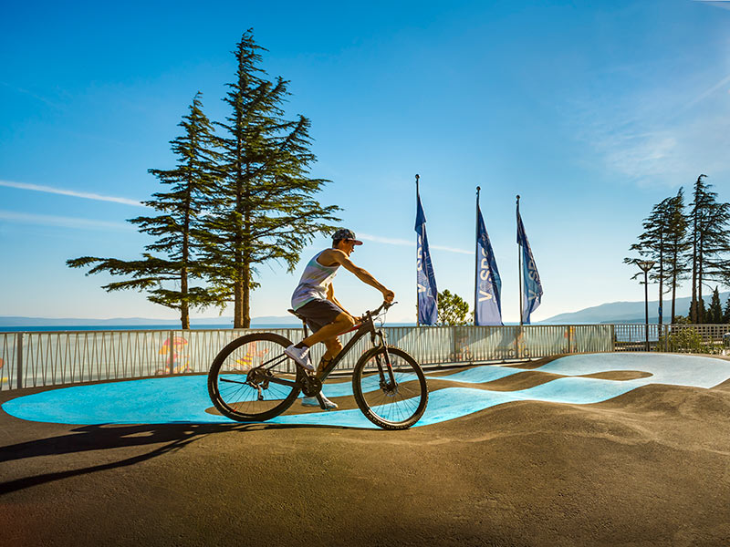 Młody rowerzysta na niebieskim torze pump track w Bike Center Rabac