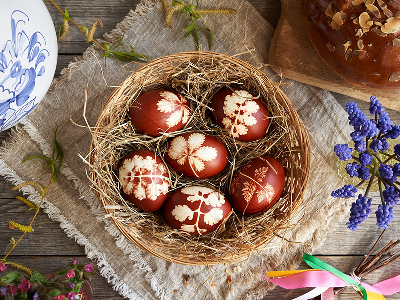 Traditional Croatian Easter eggs decorated with floral patterns in a straw nest