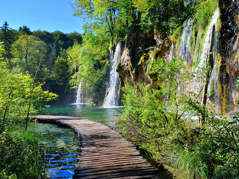 Wooden boardwalk by waterfalls in Plitvice Lakes National Park