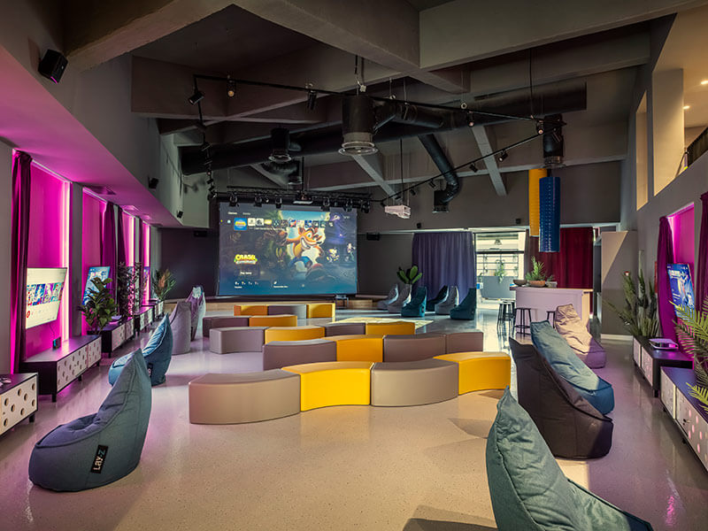 Ein kleiner Junge und ein Mädchen sitzen in Sitzsäcken und spielen Spiele auf PlayStations in der Game Lounge des Girandella Valamar Collection Resort