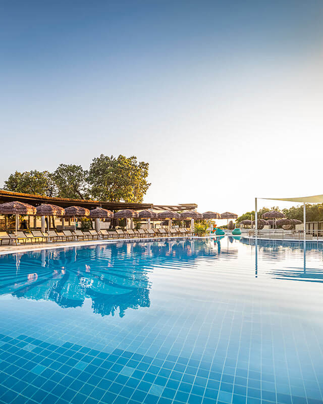Vanjski bazen s ležaljkama i suncobranima u hotelu Valamar Tirena, obiteljskom hotelu s 4 zvjezdice smještenom na slikovitom poluotoku Babin Kuk u Dubrovniku, Hrvatska