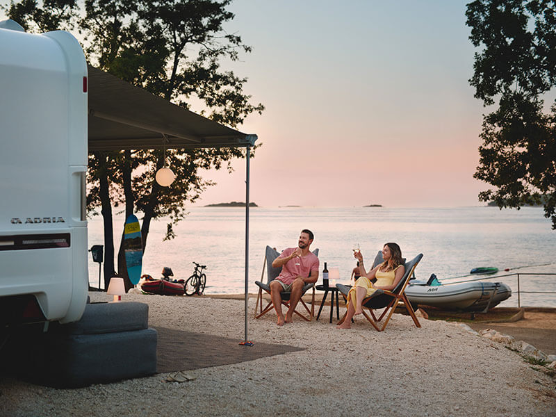 Parents et enfants profitent d'une expérience de camping en bord de mer.