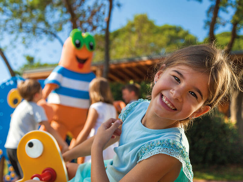 A cheerful little girl with Maro the Crab brings laughter and fun, playing with children in a family-friendly setting.