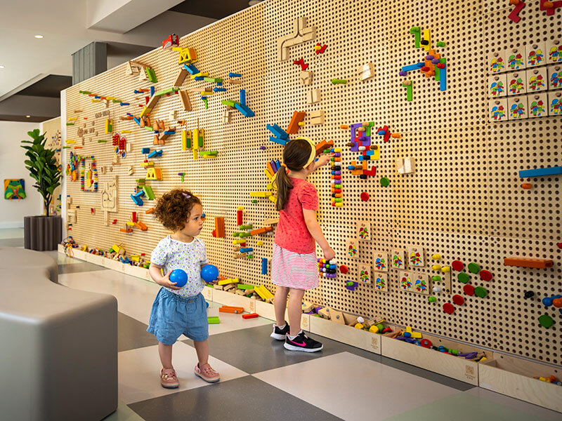 Kinder spielen mit Bauklötzen und Formen in der Smart Play Zone.