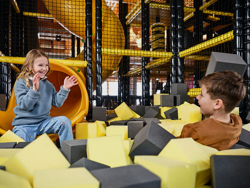 Zwei Kinder spielen auf dem weichen Maro-Spielplatz in Obertauern.