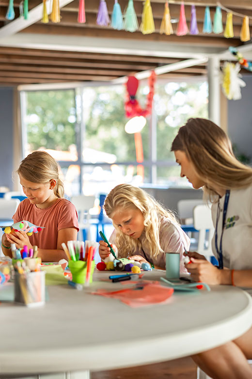 Maro babysitter and two little girls drawing in the Maro playground