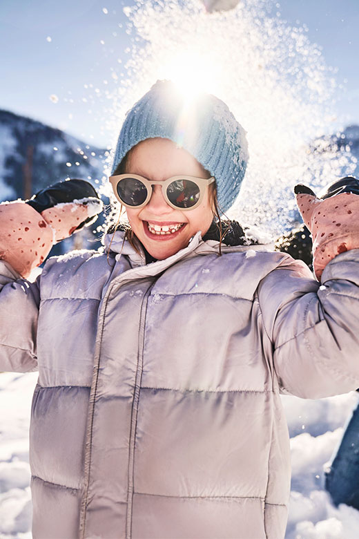 Kids enjoying a snowball fight during a family winter holiday in Austria