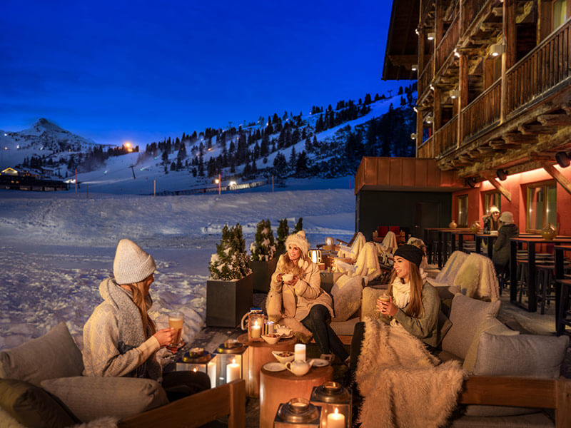 Women drinking warm drinks on the terrace of a 5-star hotel in Obertauern