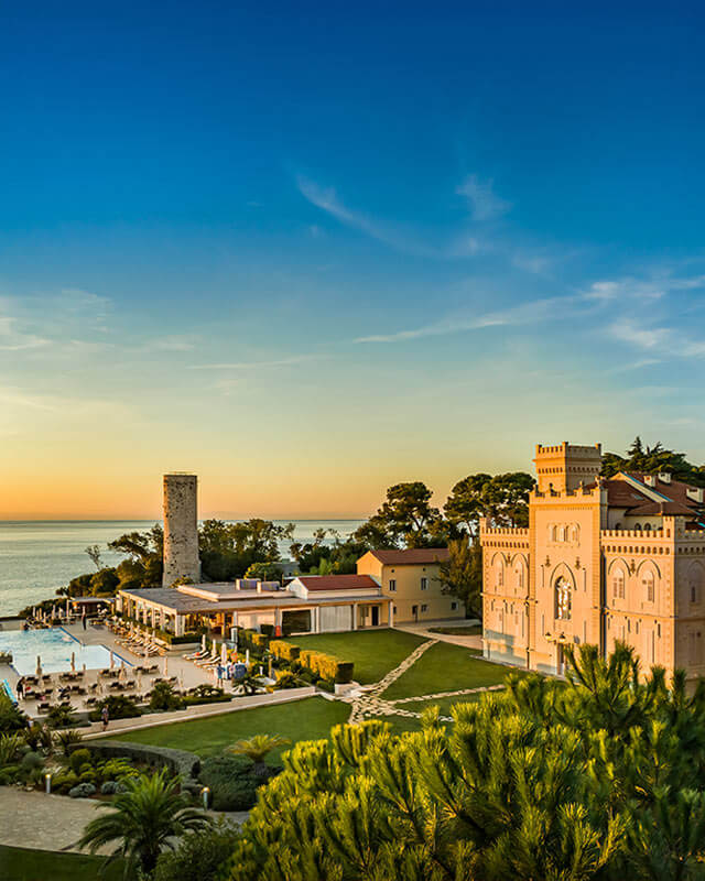 Aerial perspective of the Isabella Island Castle, nestled among lush greenery with sea surroundings.